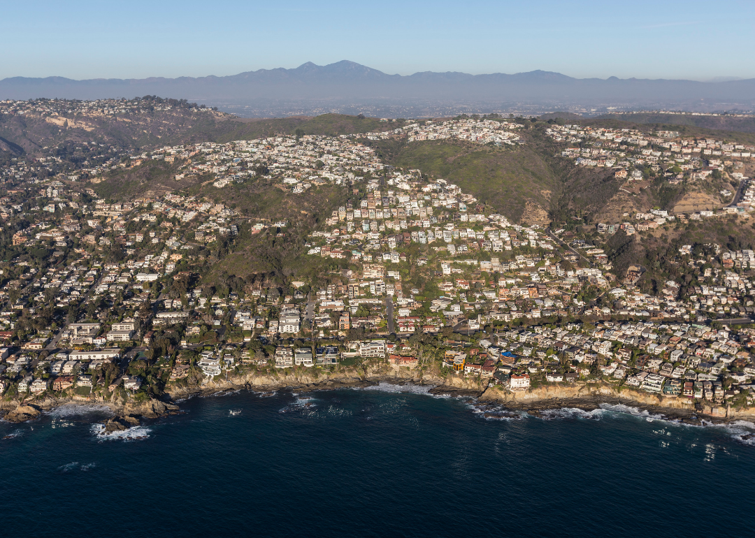An aerial view of foothills covered in homes on the water.