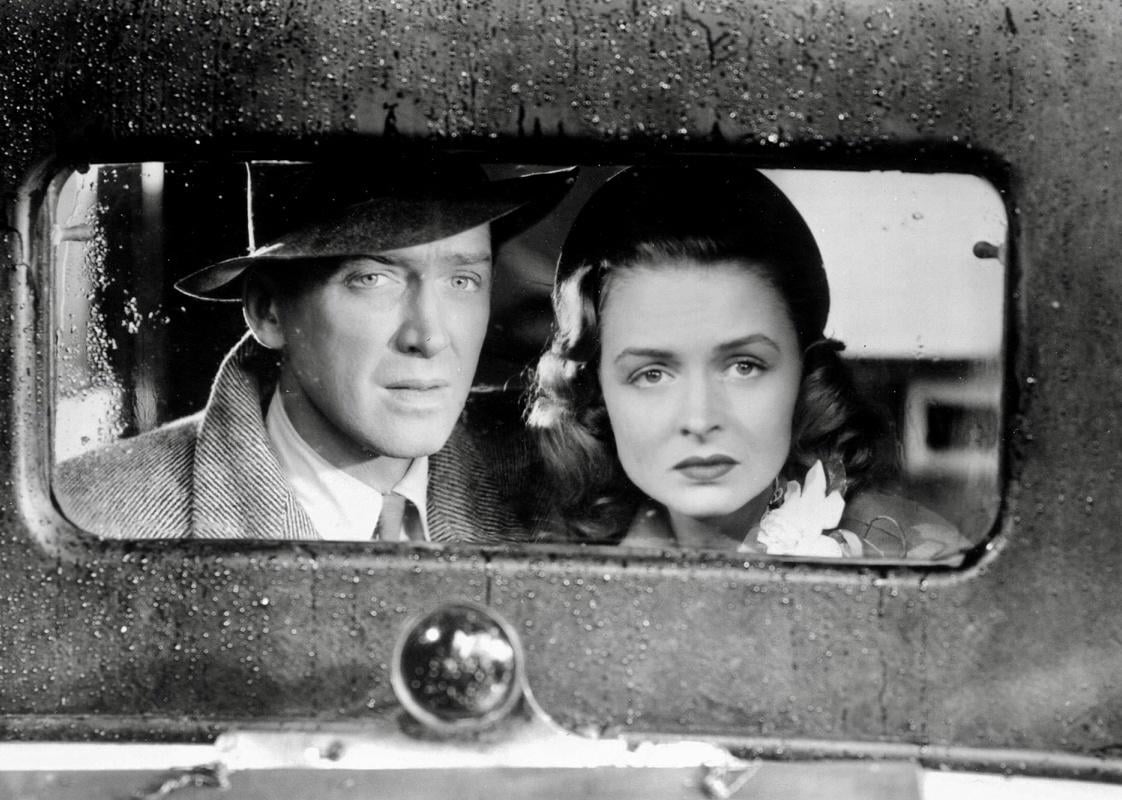 James Stewart and Donna Reed look out the window of a car.
