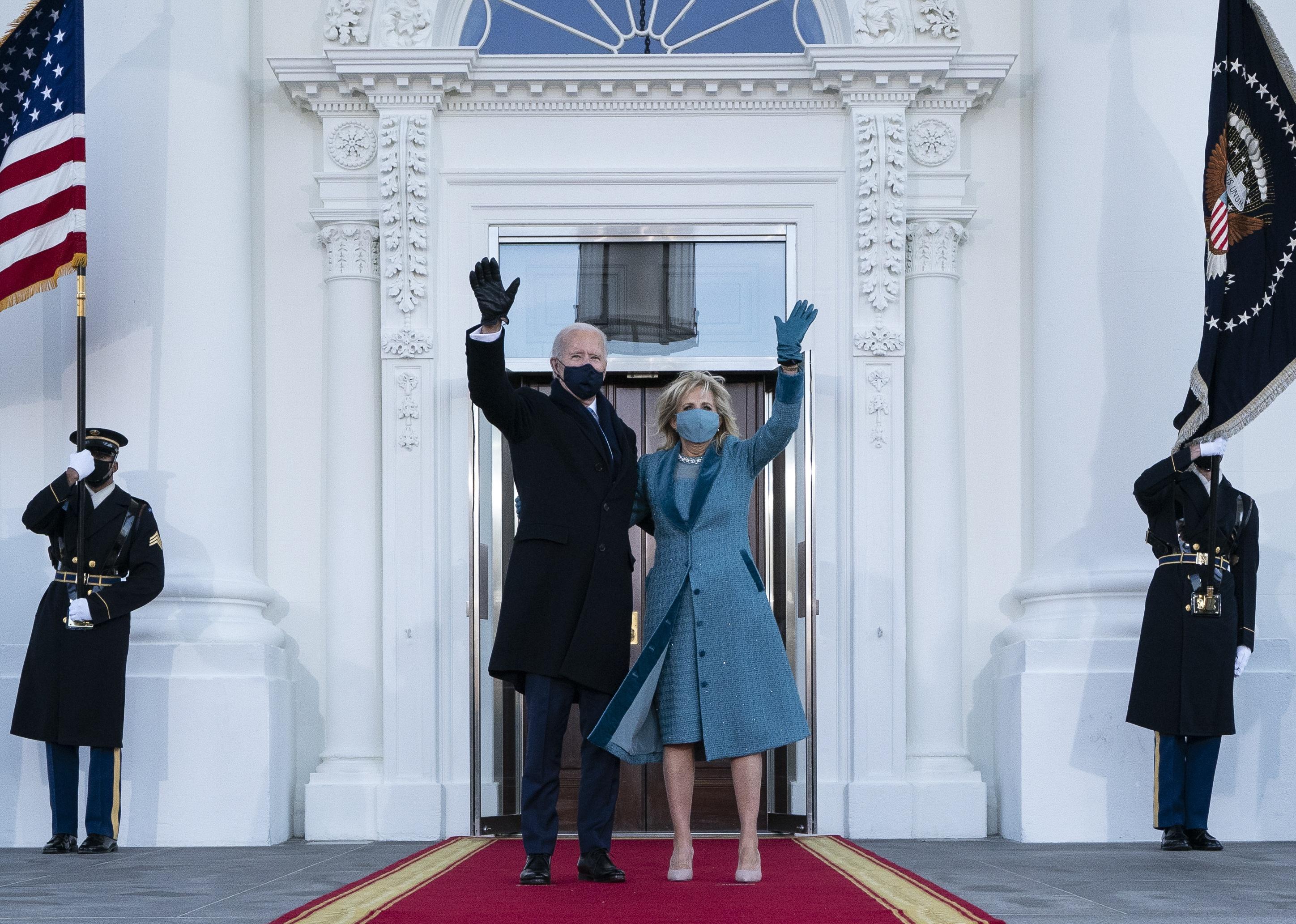 President Joe Biden and first lady Dr. Jill Biden wave as they arrive at the North Portico of the White House.