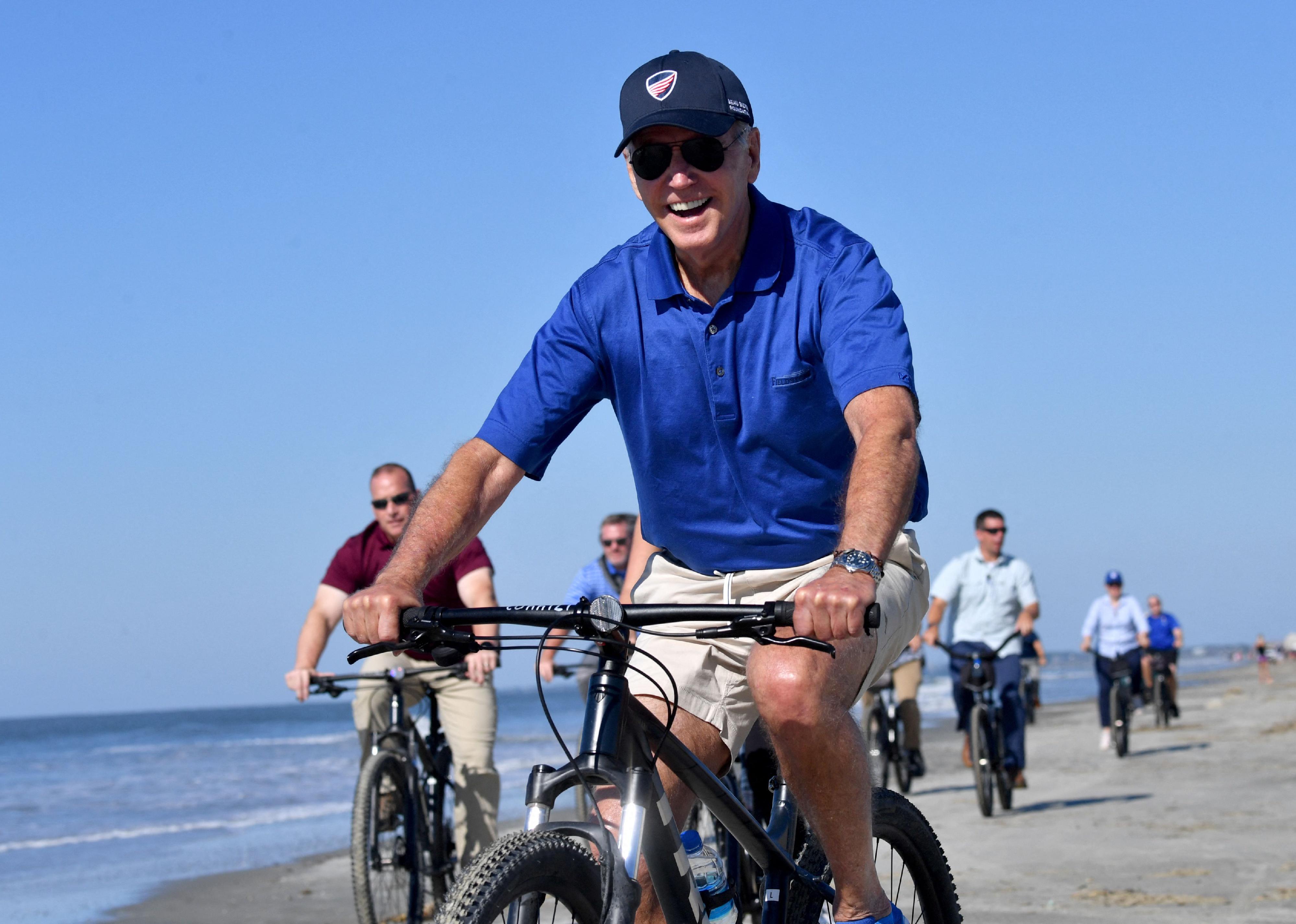 President Biden riding a bicycle on the beach in South Carolina.