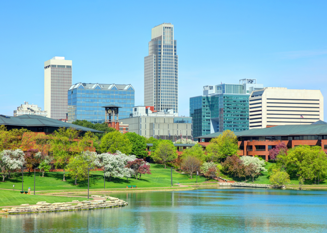 Downtown Omaha, NE skyline with a park and blooming trees in the foreground.