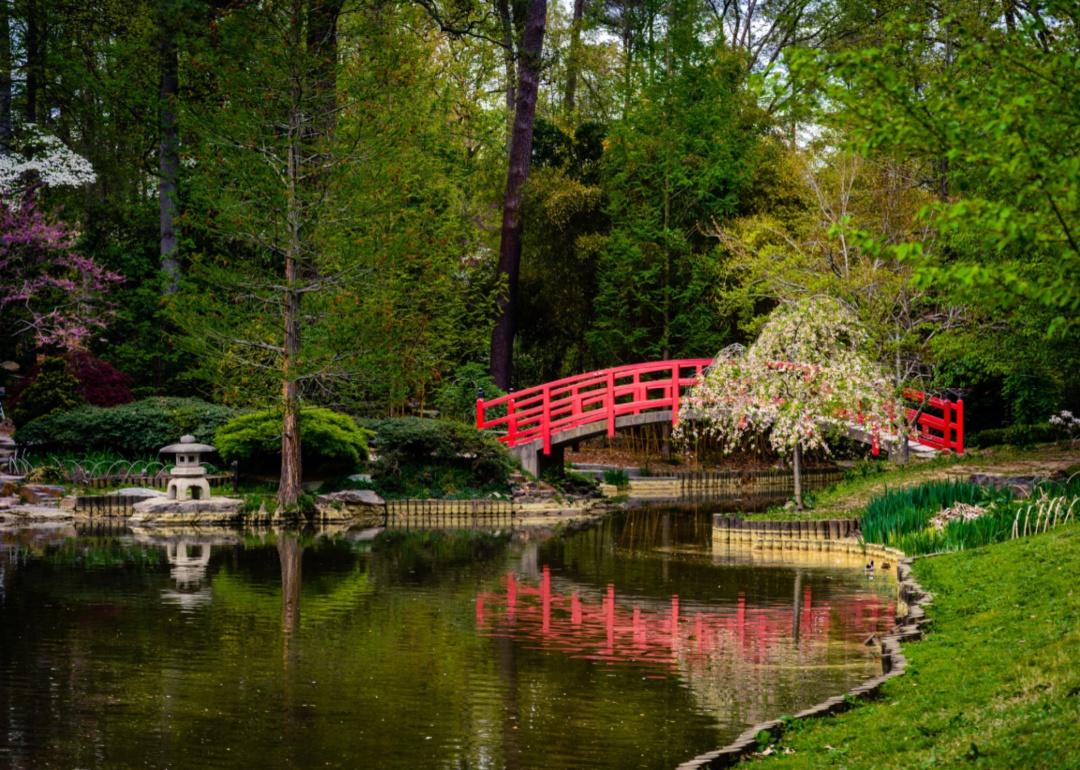 A red bridge and path in a park.