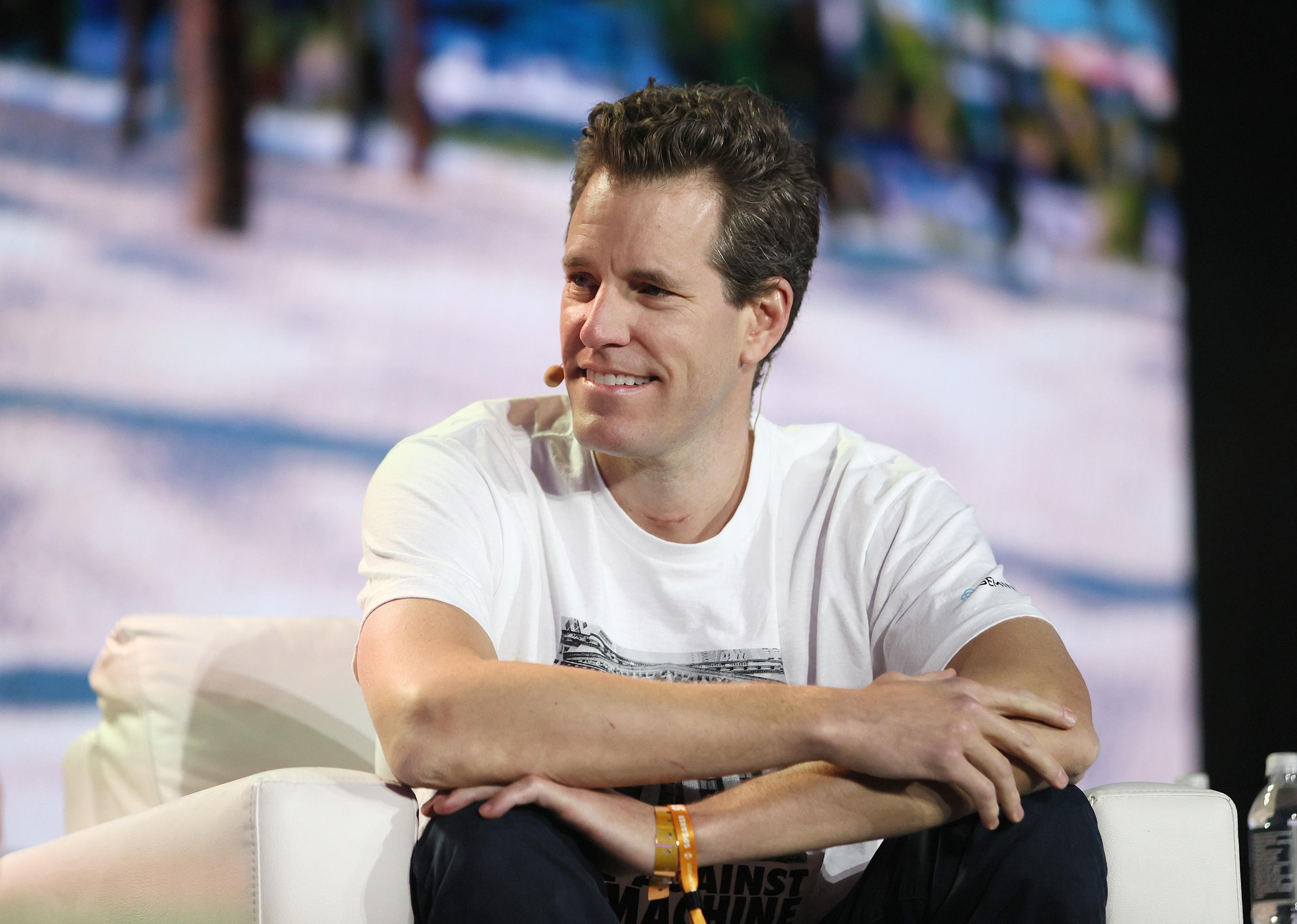 Cameron Winklevoss in a white t-shirt onstage.