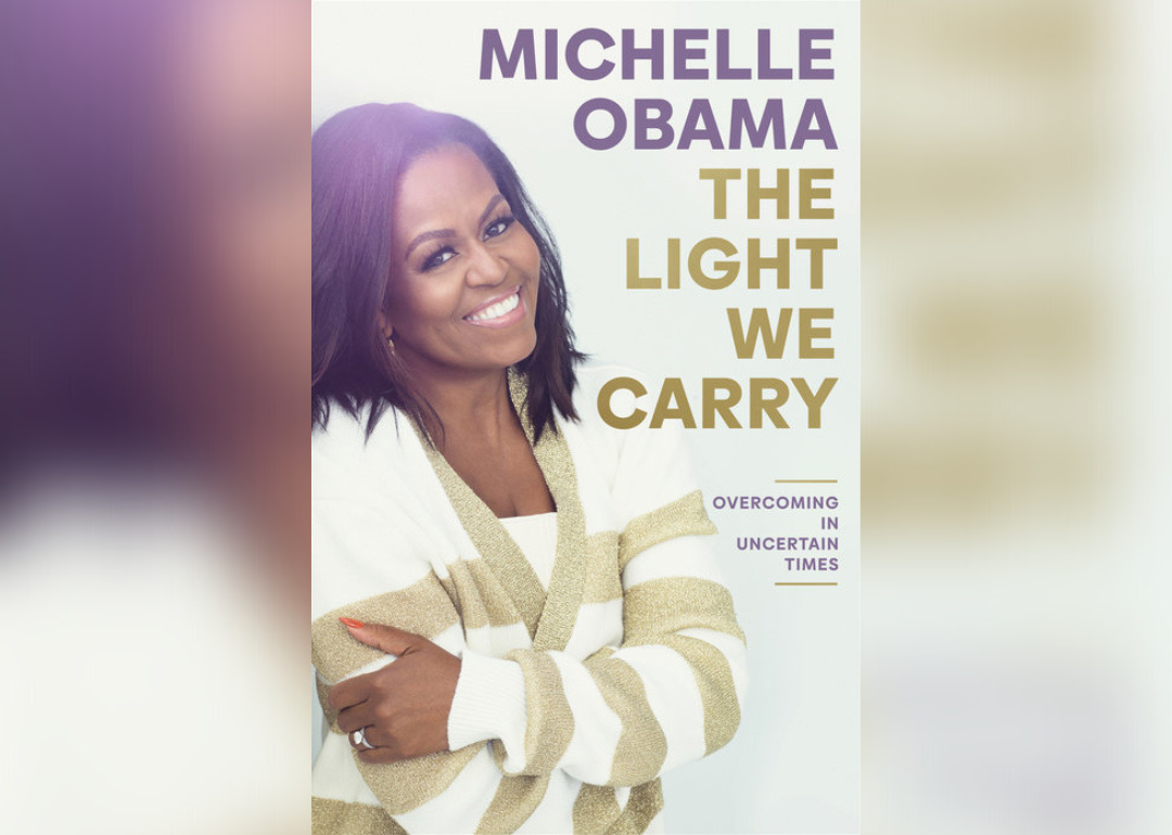 Michelle Obama in a gold and white striped sweater.