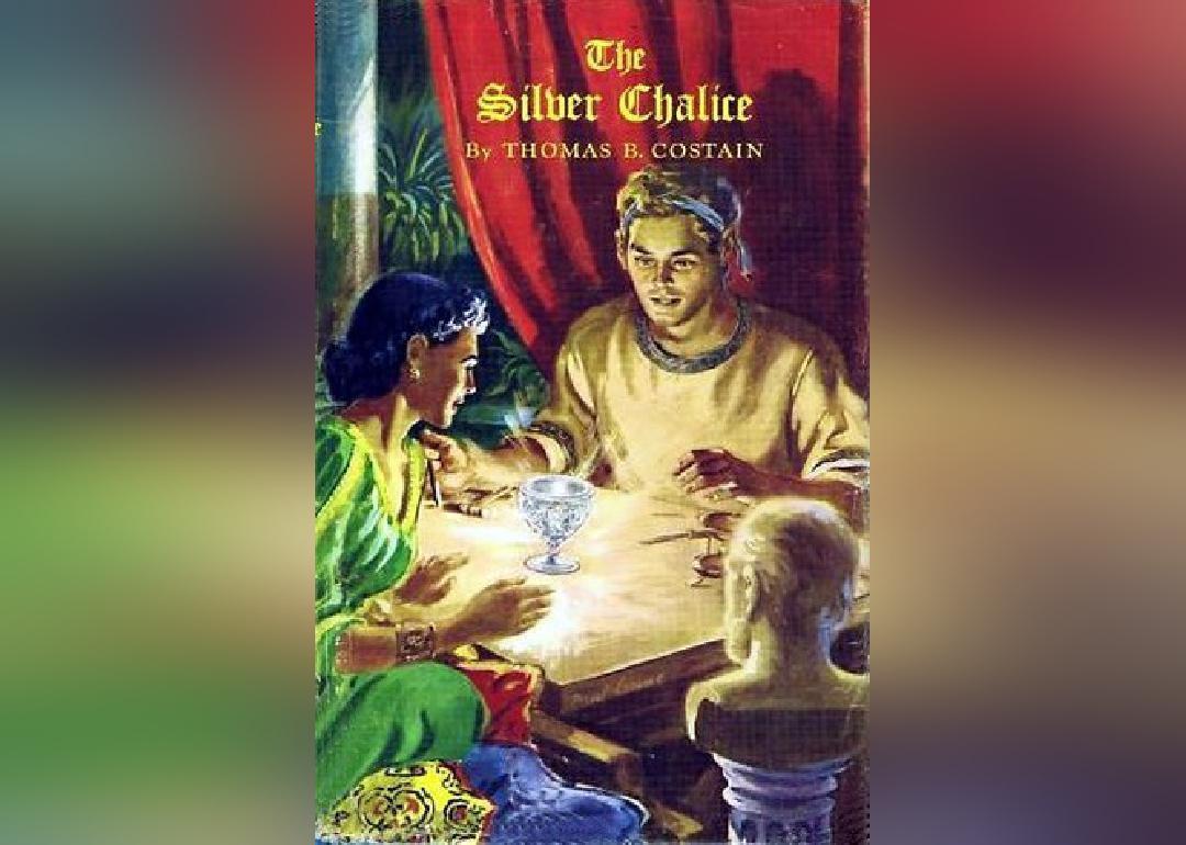 A man and woman staring at a glowing chalice.