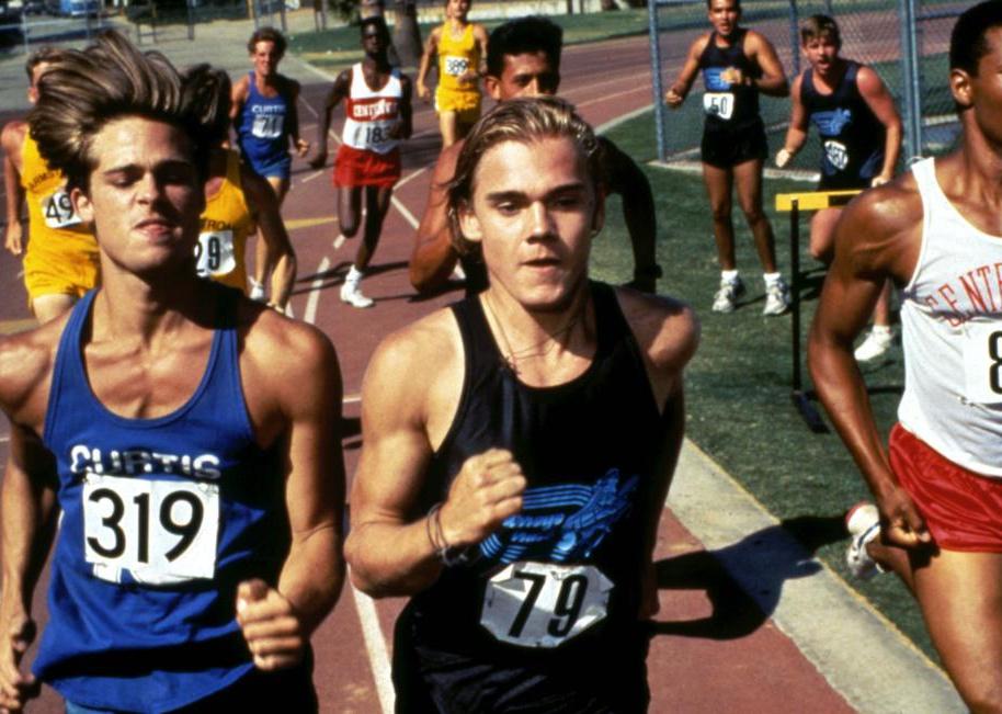 Brad Pitt and Ricky Schroder running a track race with other people.