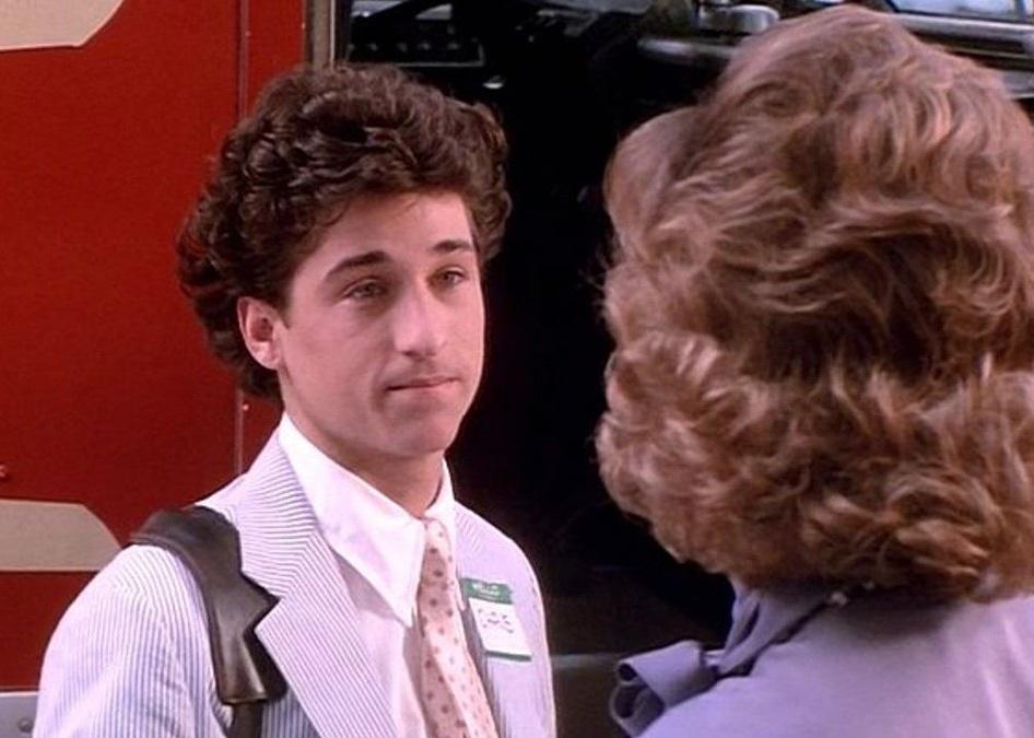 Patrick Dempsey in a seersucker jacket looking at a woman.
