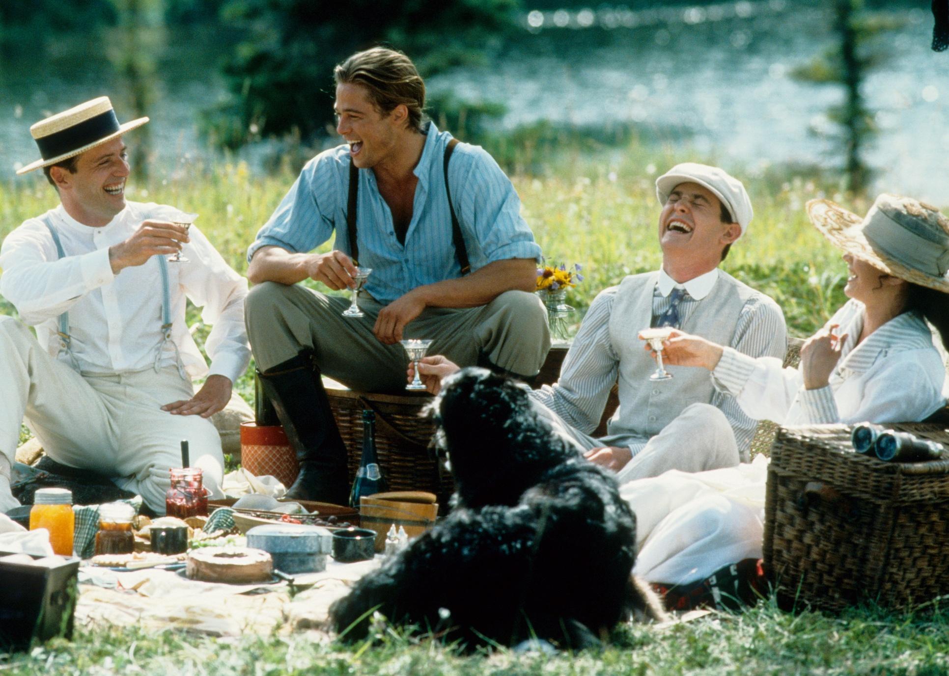 Brad Pitt, Julia Ormond, Aidan Quinn, and Henry Thomas having a picnic and laughing.