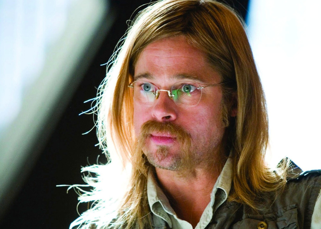 Brad Pitt with long hair, glasses and a handlebar mustache.
