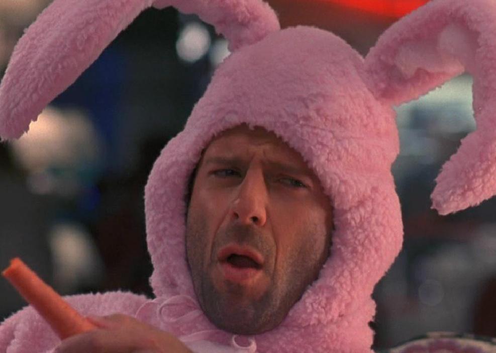 Bruce Willis in a pink bunny suit making a funny face.