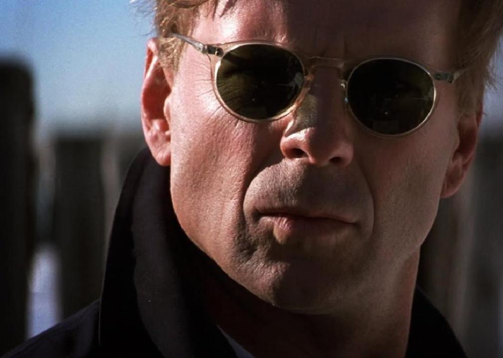 Close up of Bruce Willis wearing small round framed sunglasses.