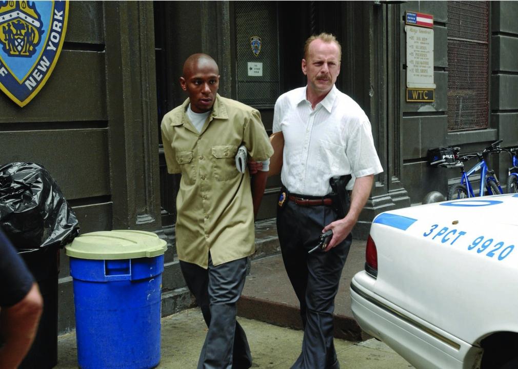 A police officer escorts a man in handcuffs outside a New York police station.