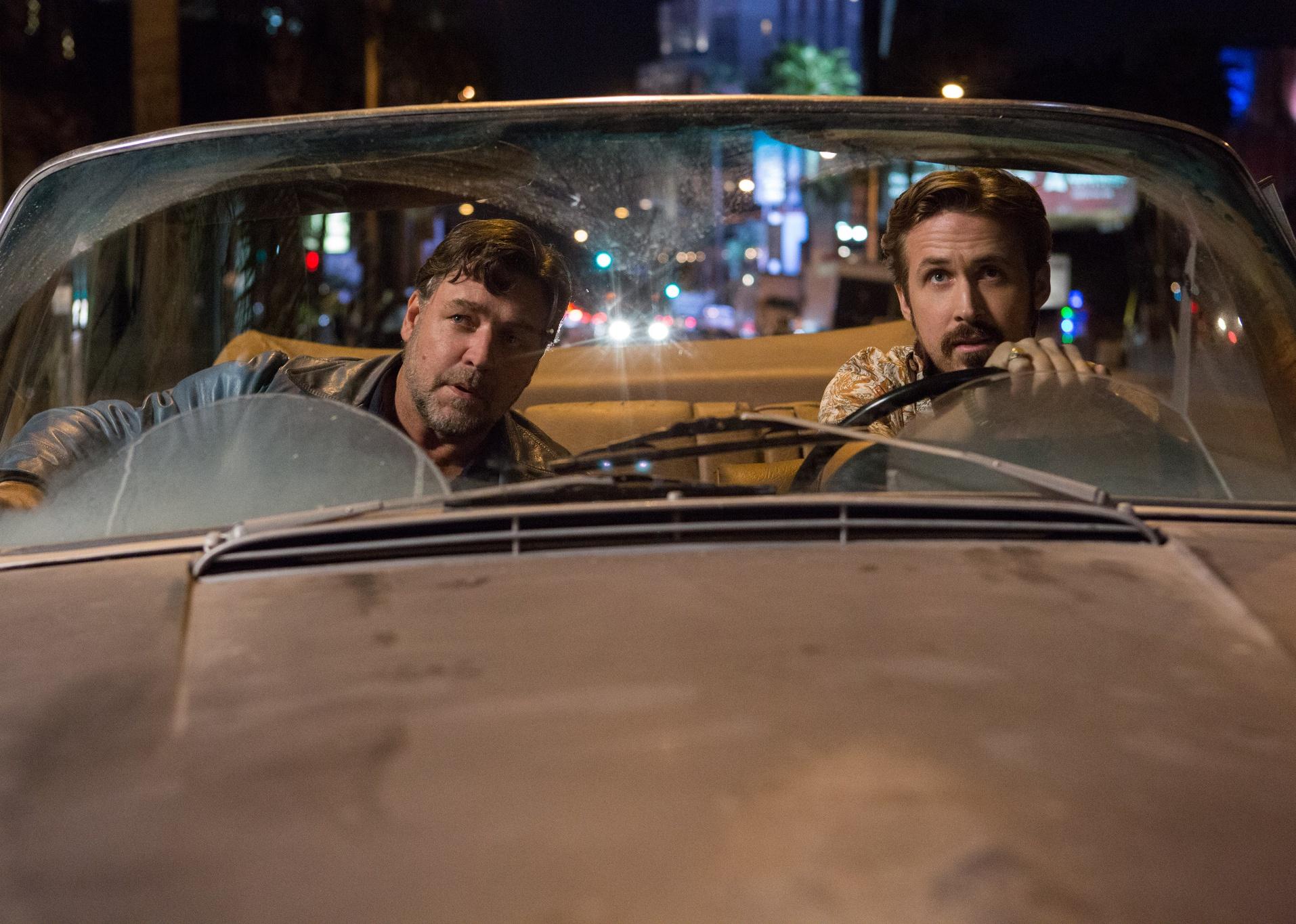 Russell Crowe and Ryan Gosling in a convertible at night.