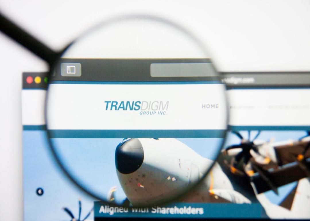 A magnifying glass over the Transdigm website showing an airplane.