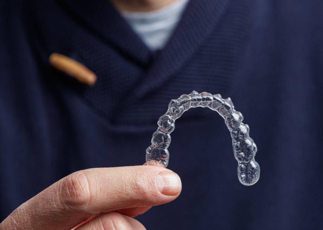 A person holding an invisalign mouth insert.