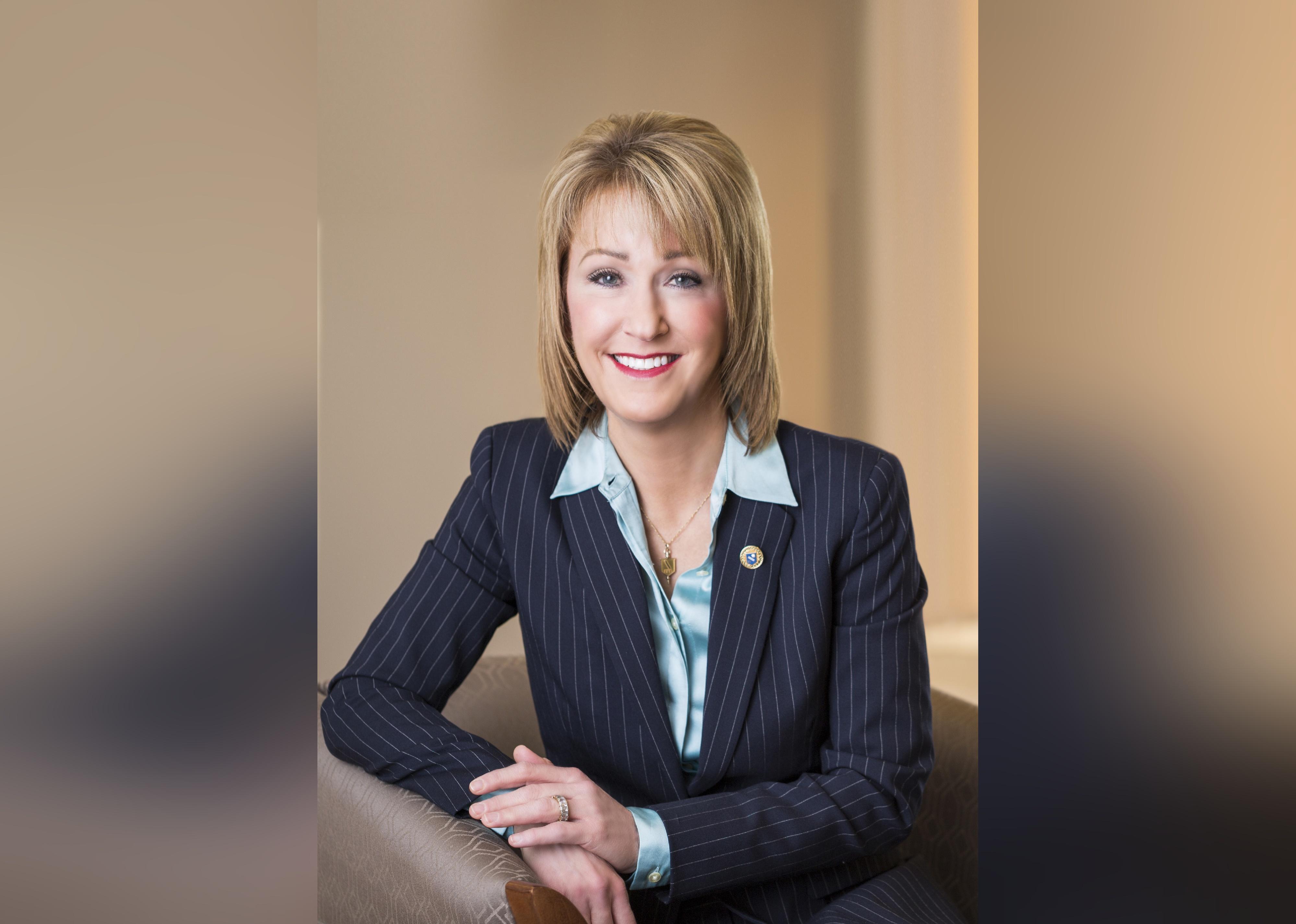 Kathleen Mazzarella posing in a pinstripe suit.