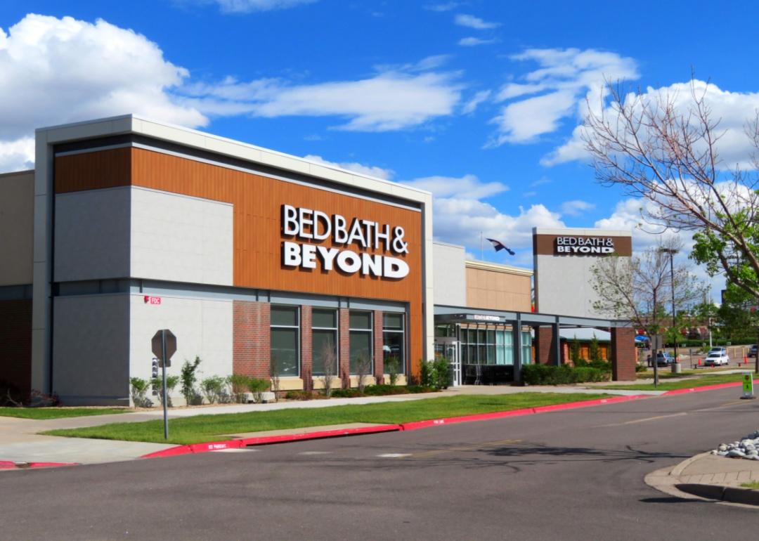 The exterior of a Bed, Bath & Beyond store under a blue sky.