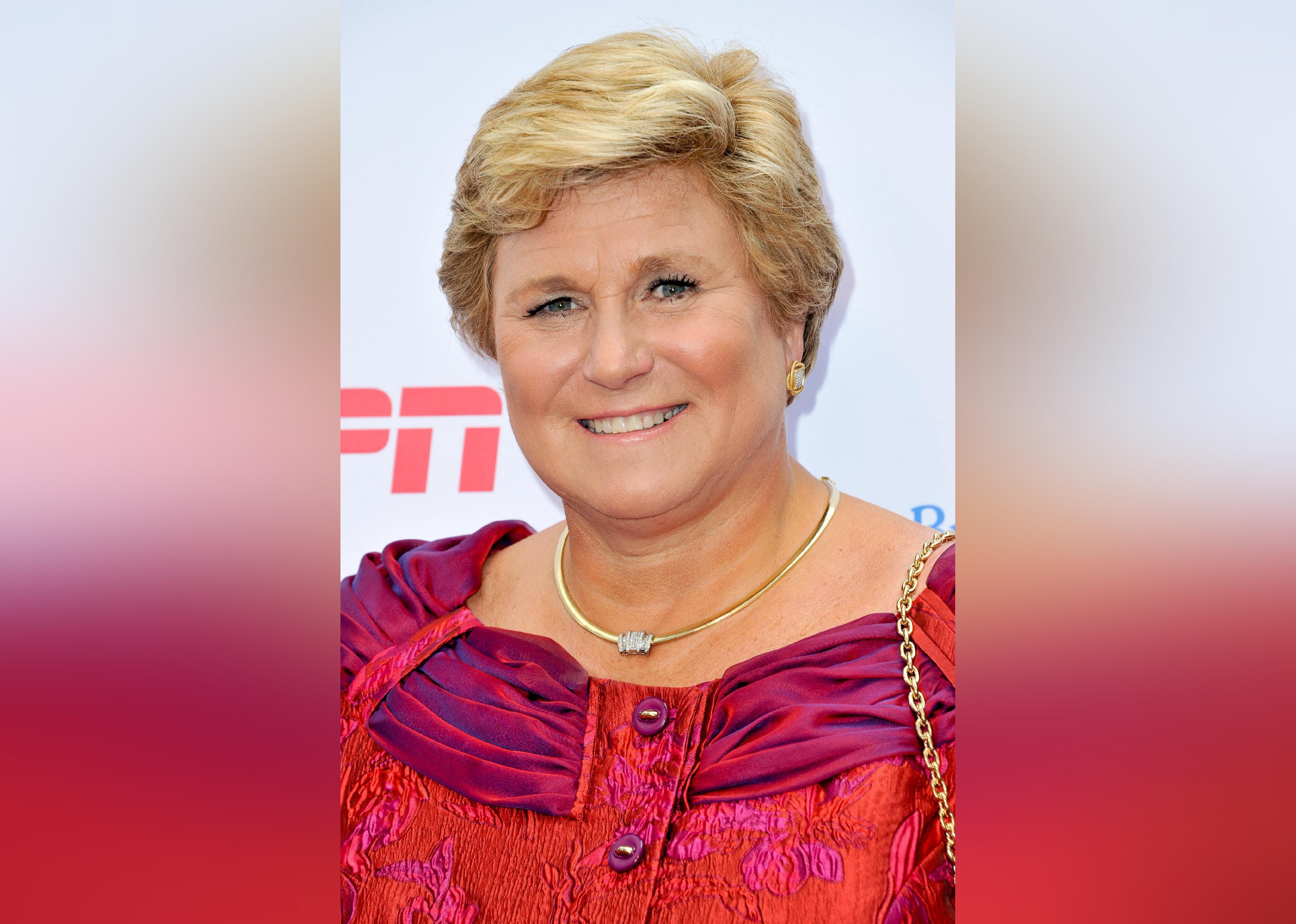 Gail Boudreaux in a pink and purple gown smiling.