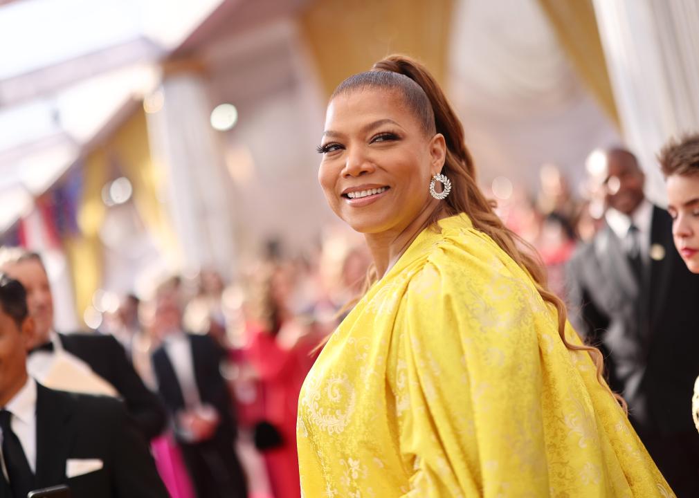 Queen Latifah poses in a yellow gown.