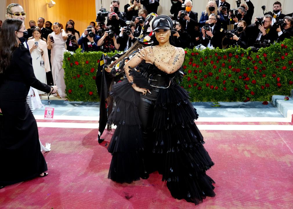 Nicki Minaj wearing a black ruffled tulle gown with a black leather body suit underneath and hat.