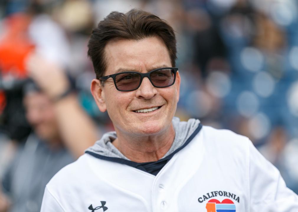 Charlie Sheen wearing a softball jersey at a game.