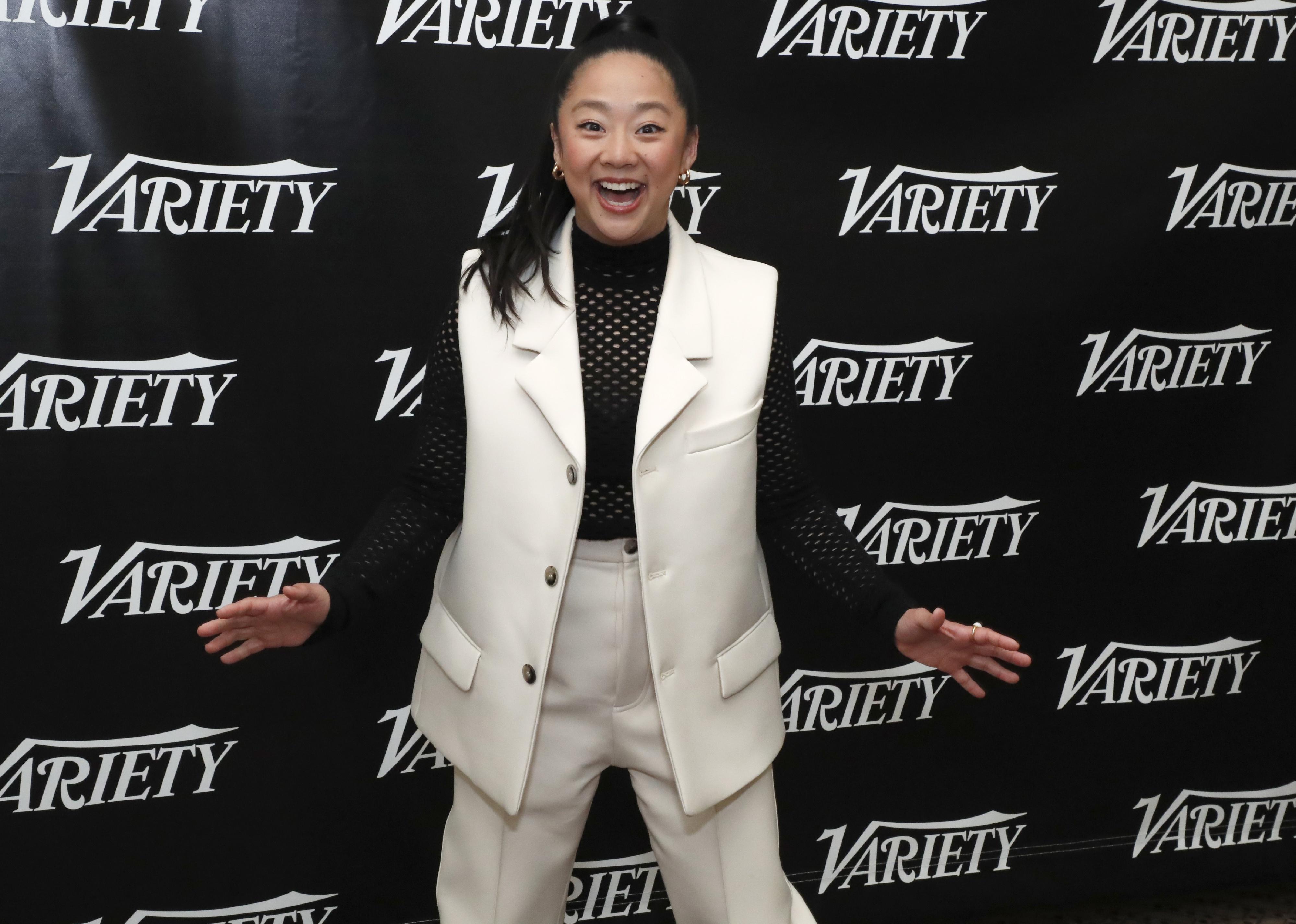 Stephanie Hsu in white pants and a vest.