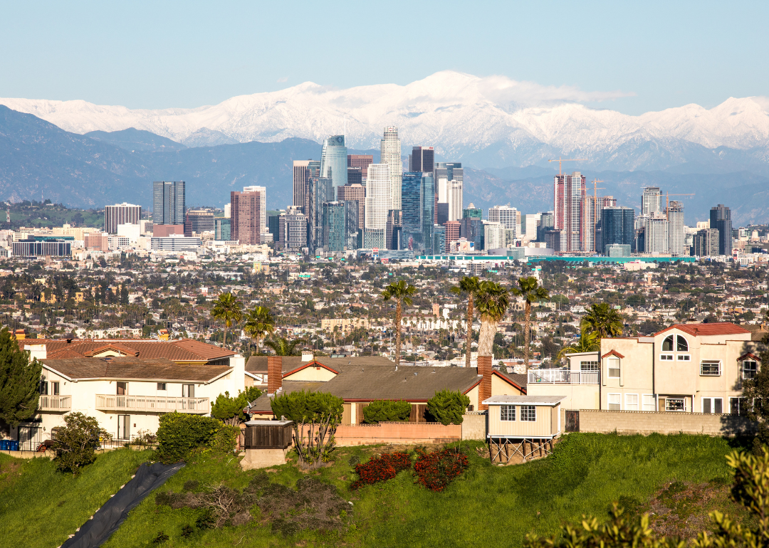 Homes on a hill with the Los Angeles skyline in the background.