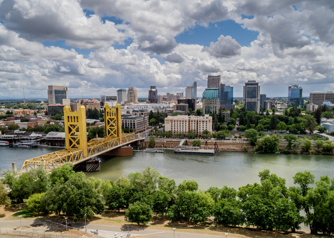 A yellow bridge going over the water to downtown Sacramento.