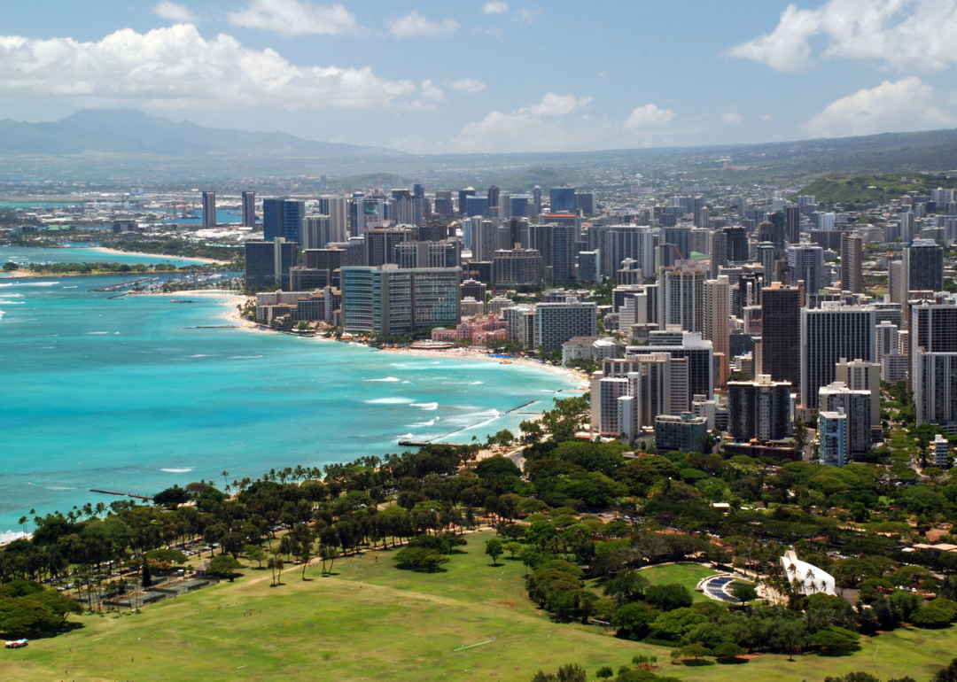 An aerial view of downtown Honolulu on turquoise water.