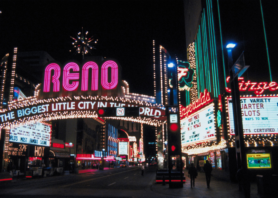 Neon lights and a big arch at night in downtown Reno.