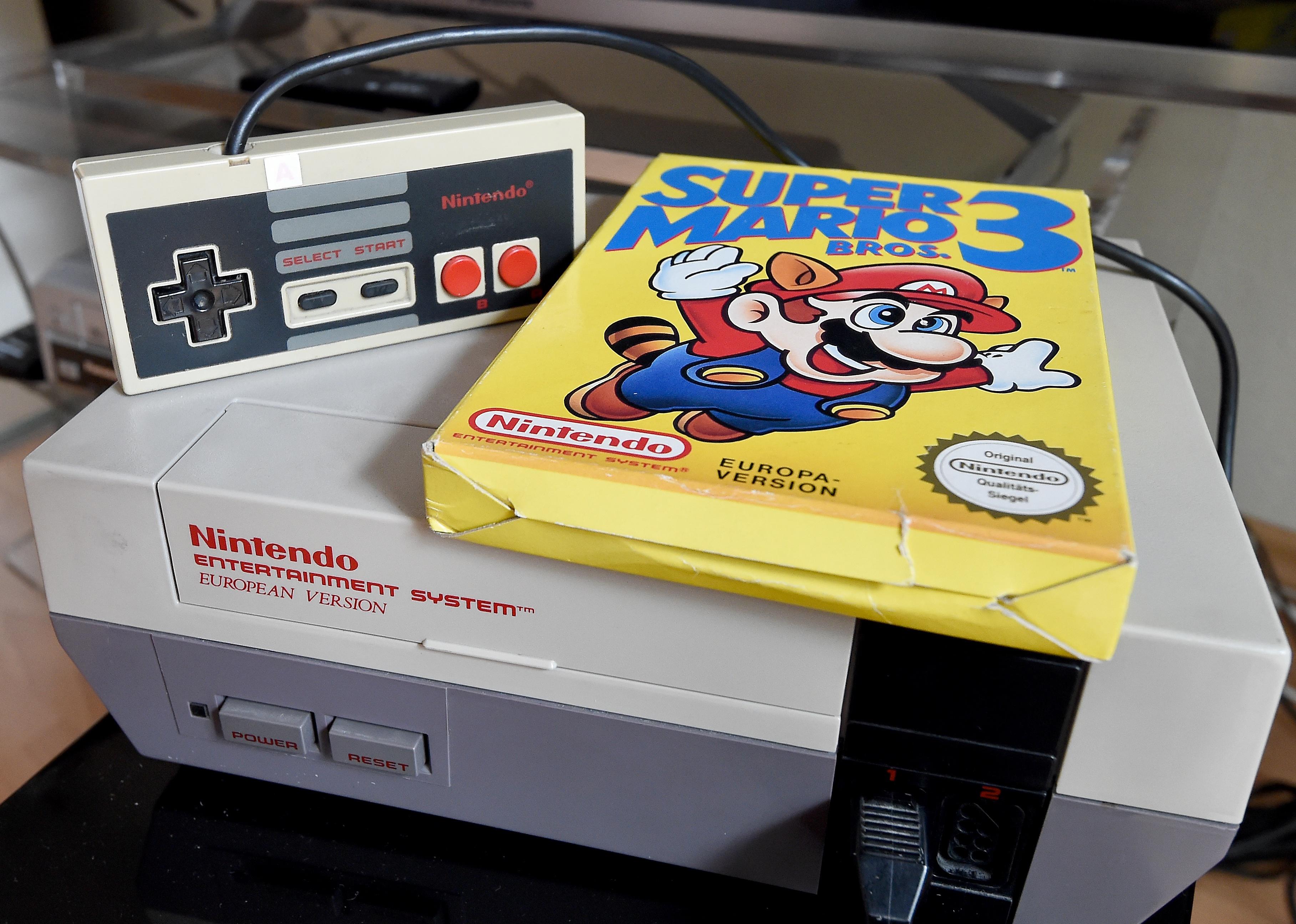 A 'Super Mario 3' game is on top of a 1980's NES games console.