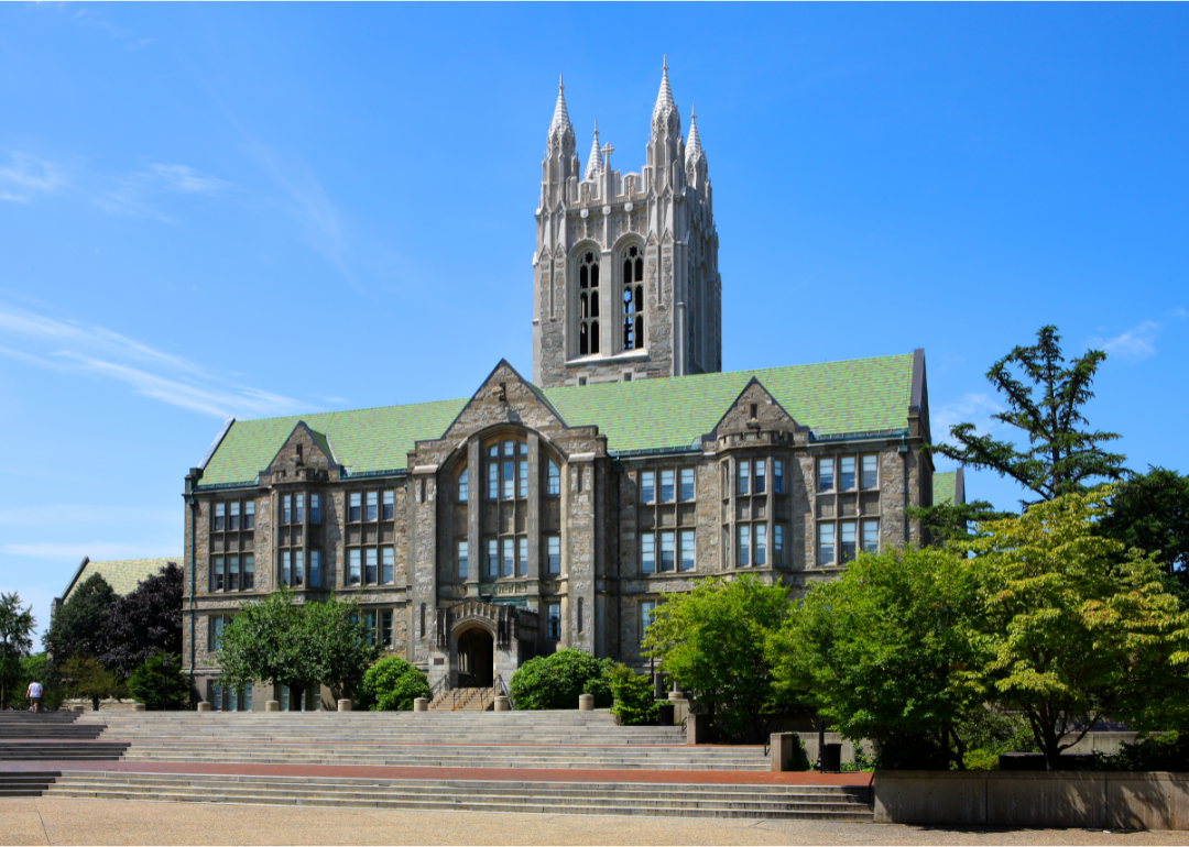 A historic gray stone college with a green roof in Boston.