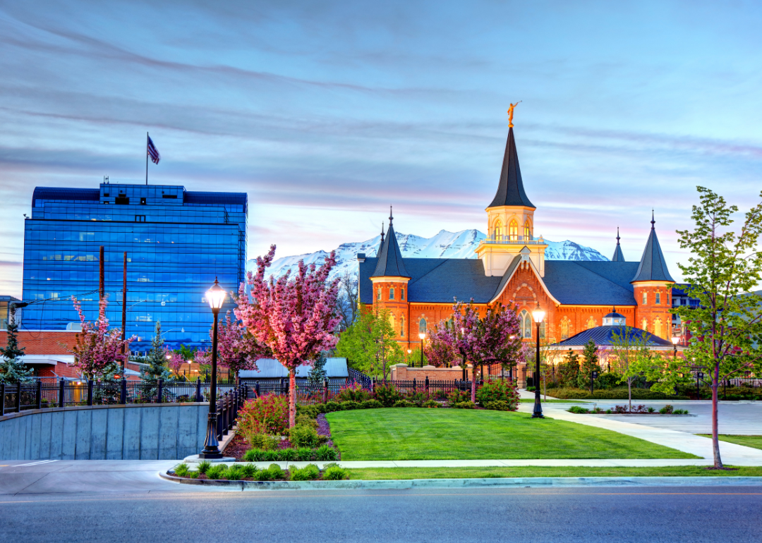 A modern and a historic building in Provo in front of snowy mountains.