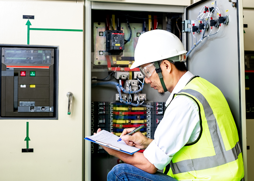 An electrical engineer inspecting a switchgear cabinet.