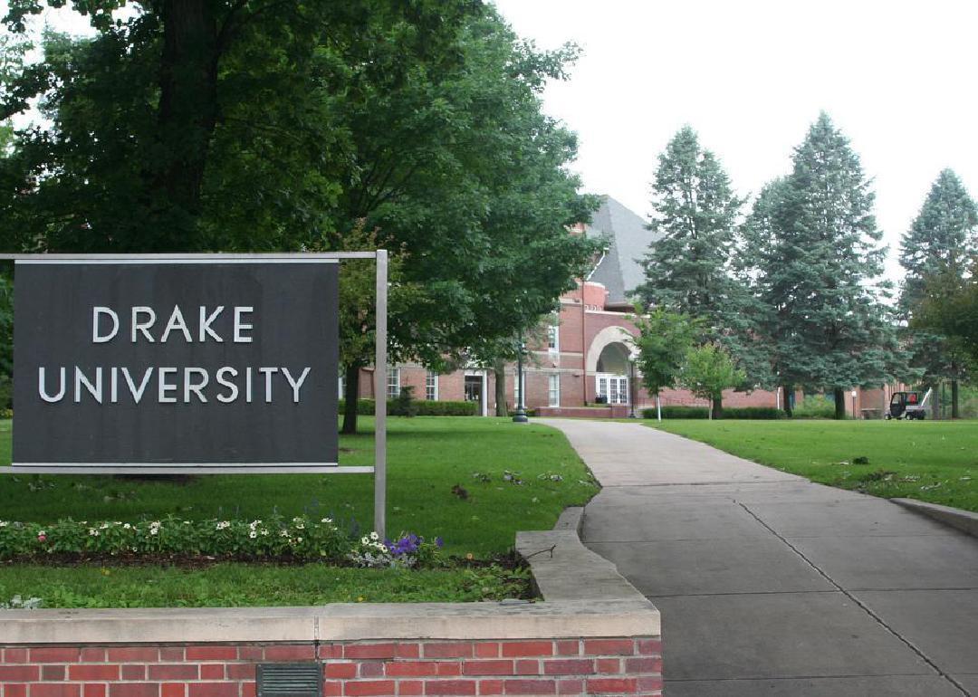 A red brick entrance wall and black sign for Drake University.