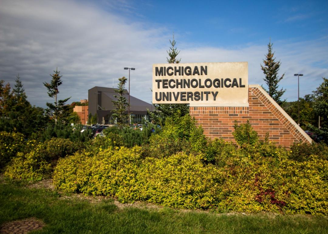 A stone sign for Michigan Tech surrounded by greenery.