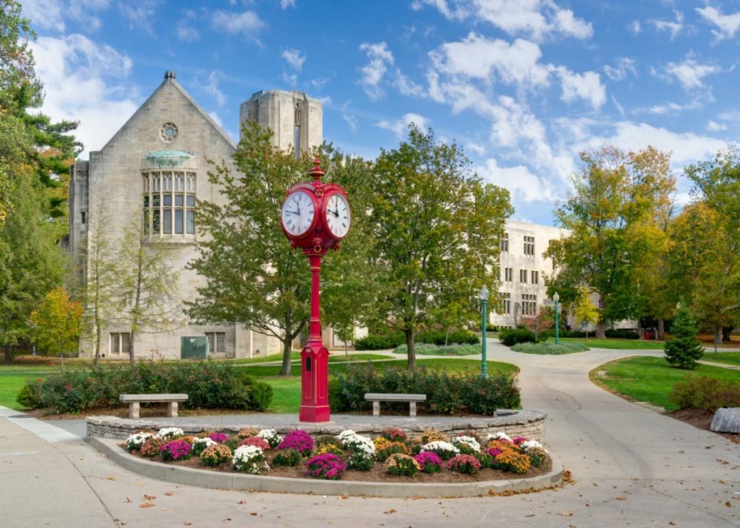 A historic stone building with a red clock in the courtyard.