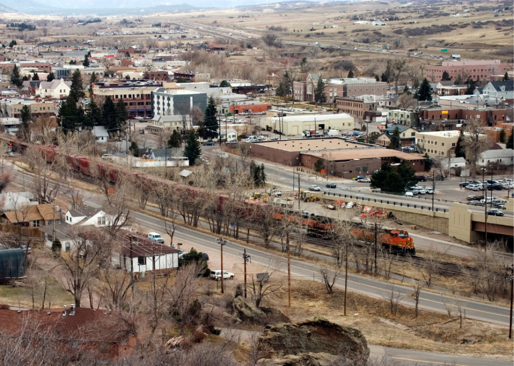 An aerial view of a rural town with a train running through it. 