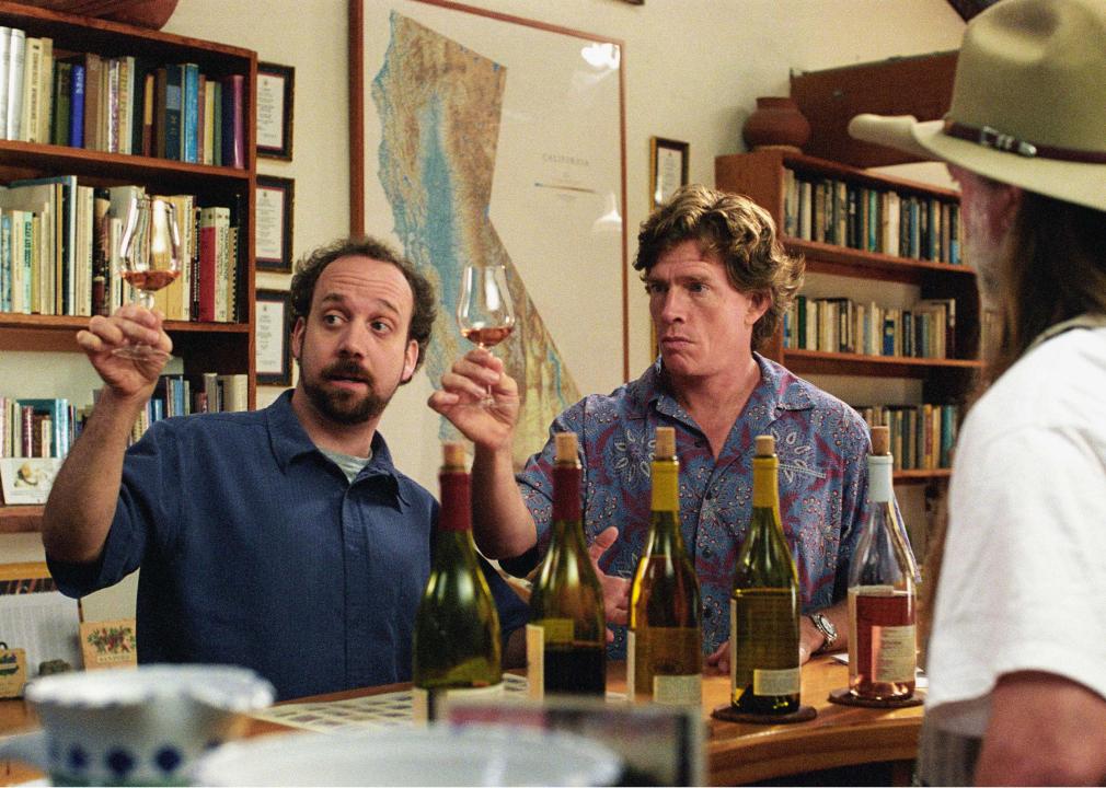 Two men hold up wine glasses at a tasting.