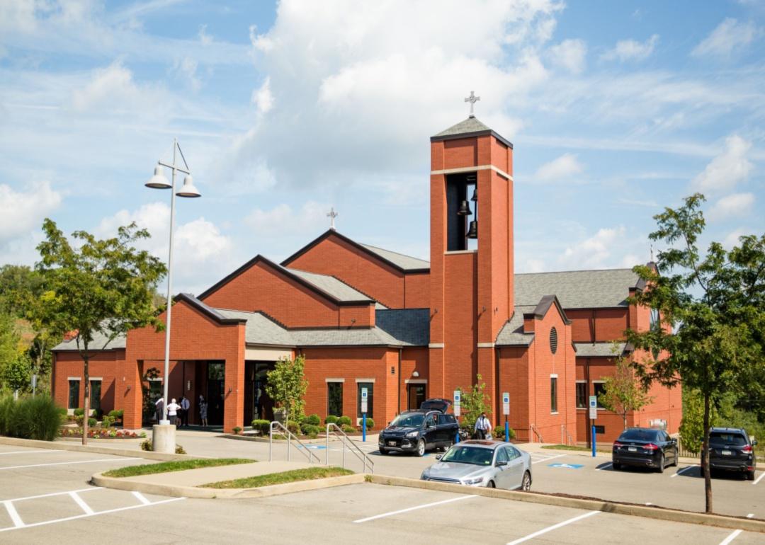A red stone church and parking lot.