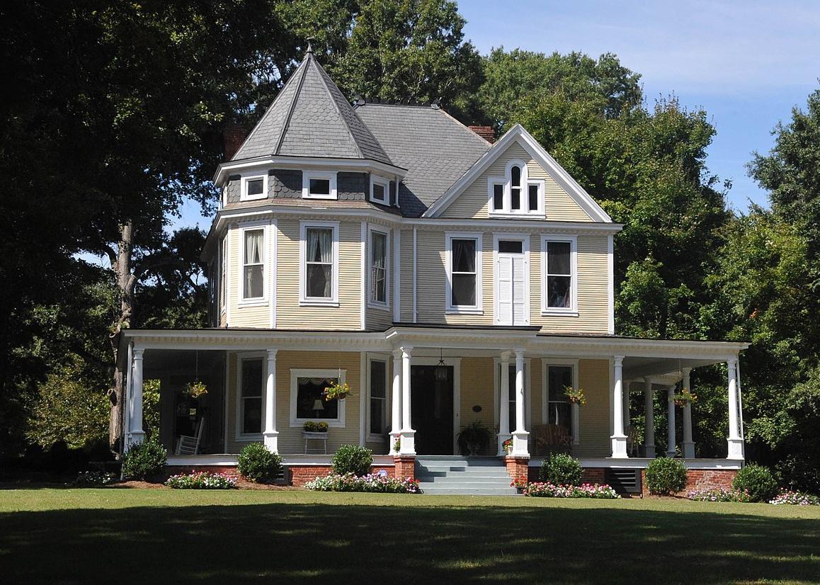 A historic Queen Anne style yellow home.