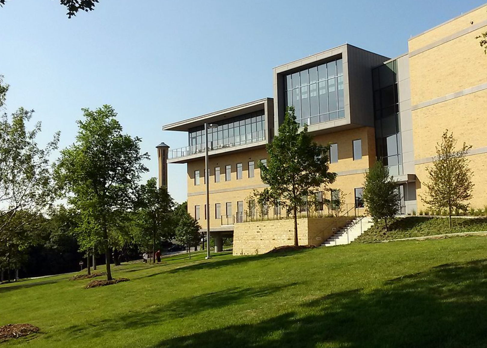 A stone building on a hill with all glass on the top floor.