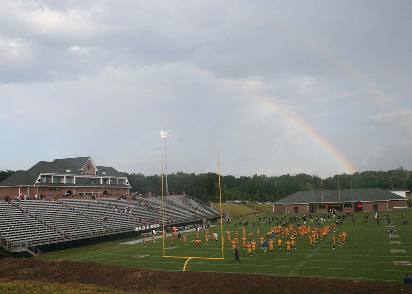 A football game with a rainbow in the background.