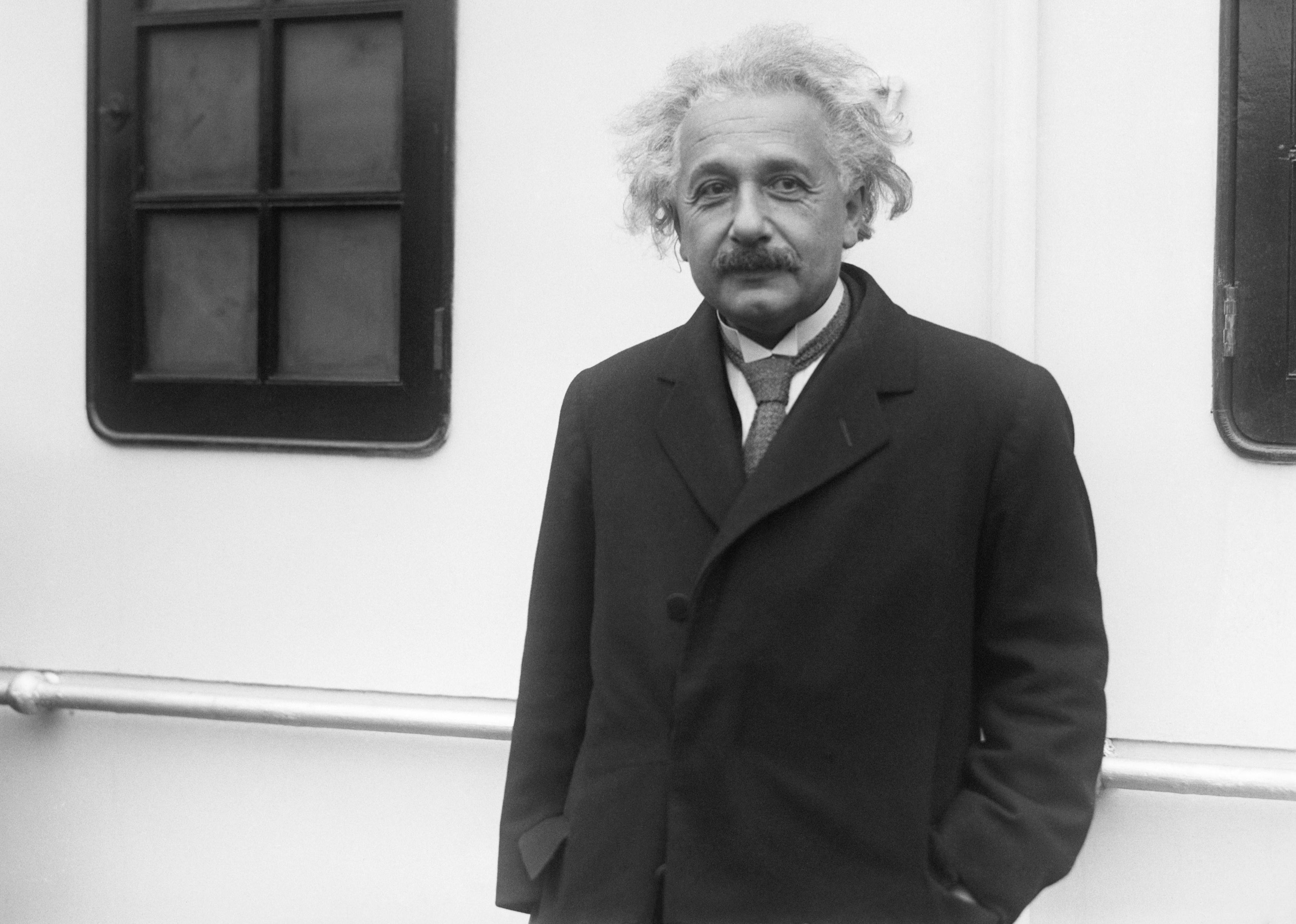 Albert Einstein in a long dark coat.