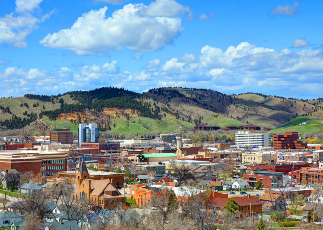 Aerial view of Rapid City backed by hills.