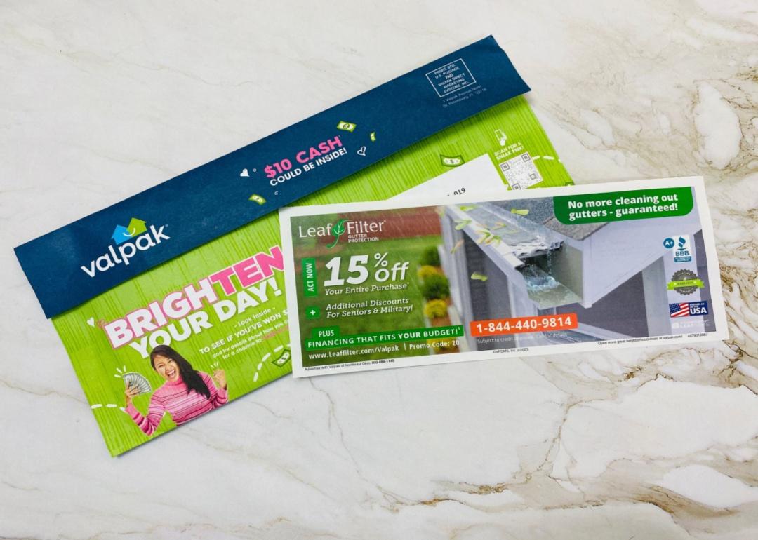 A Valpak stack of coupons on a table.