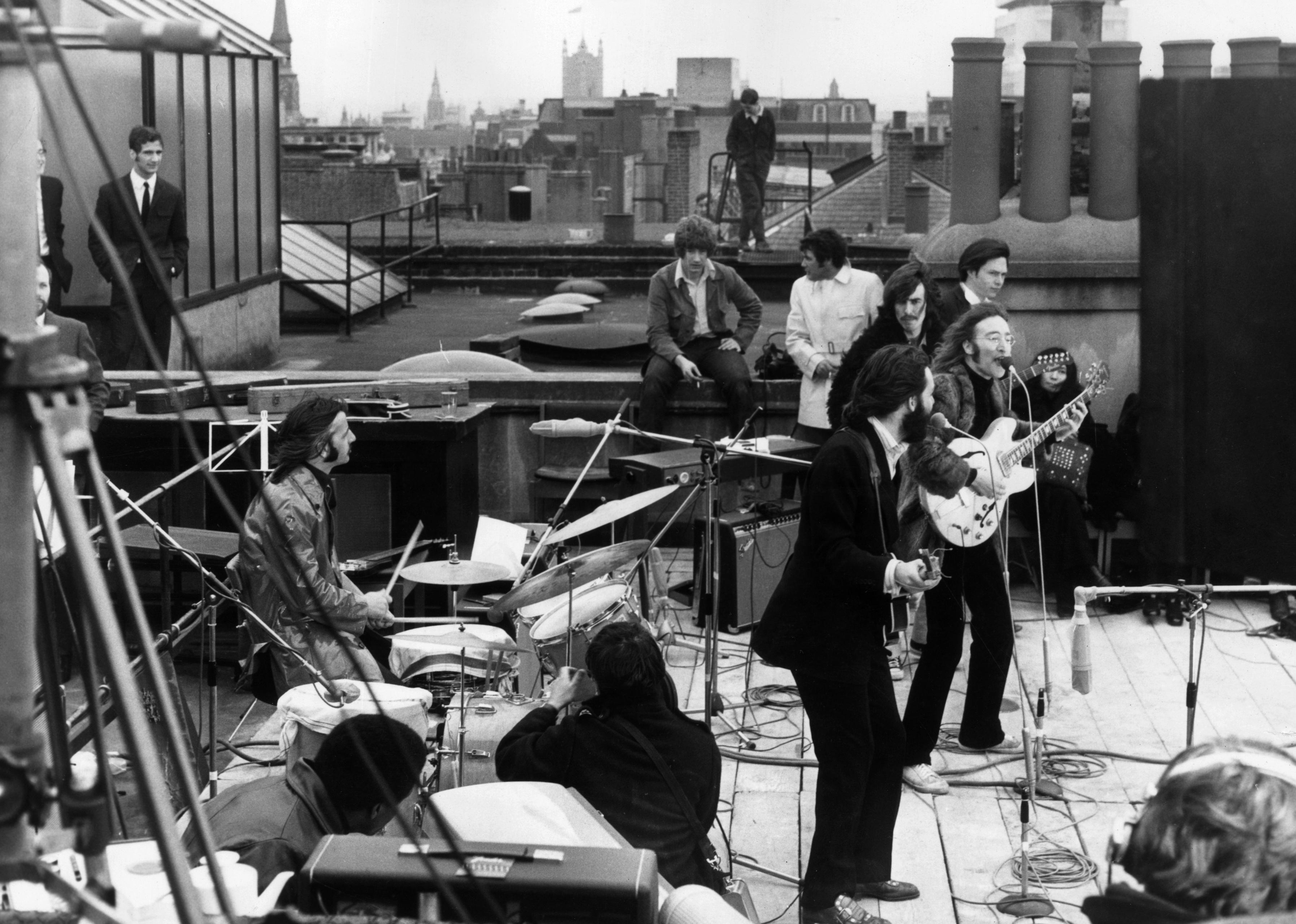 The Beatles performing on a rooftop.