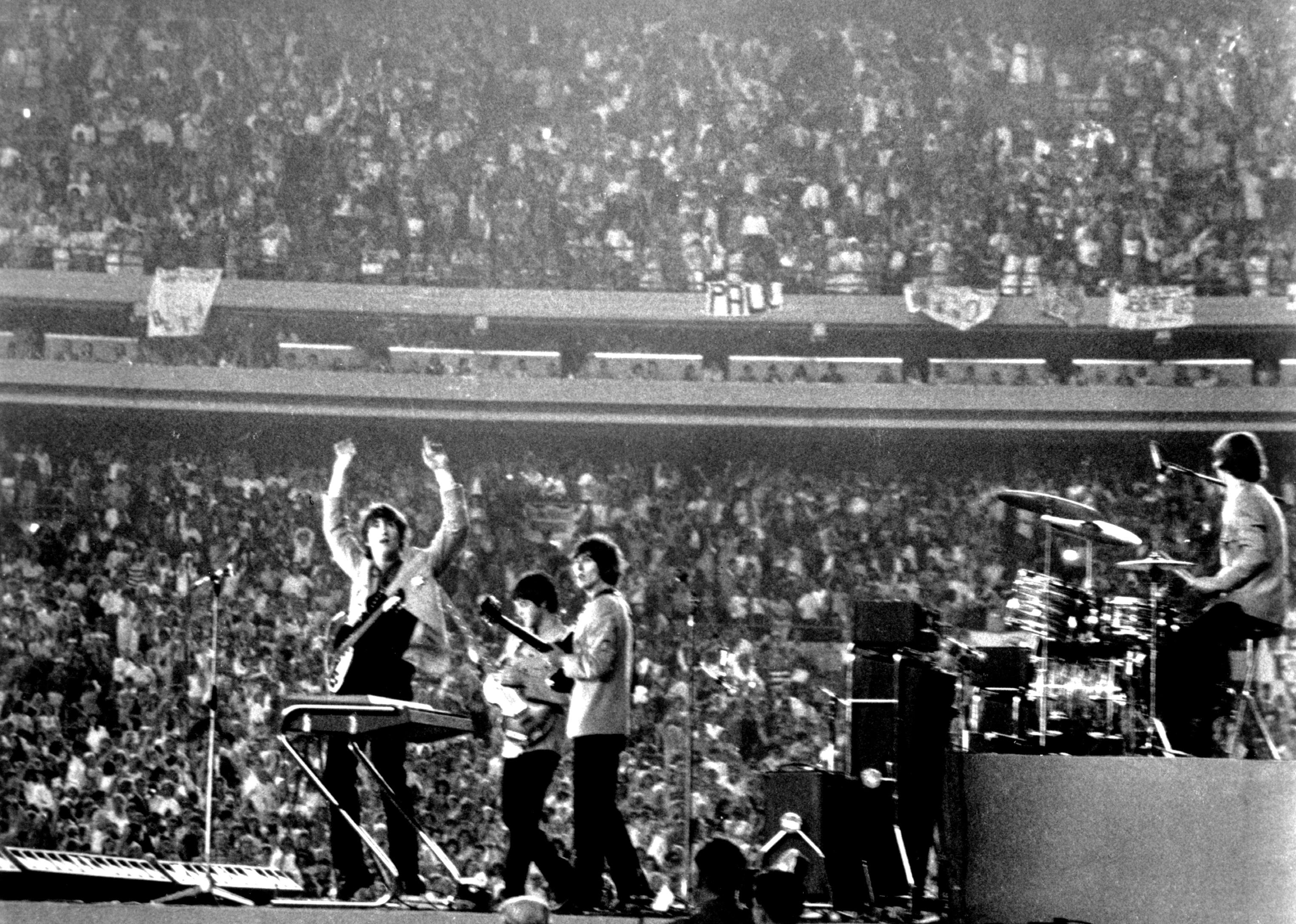 The Beatles performing at a stadium.