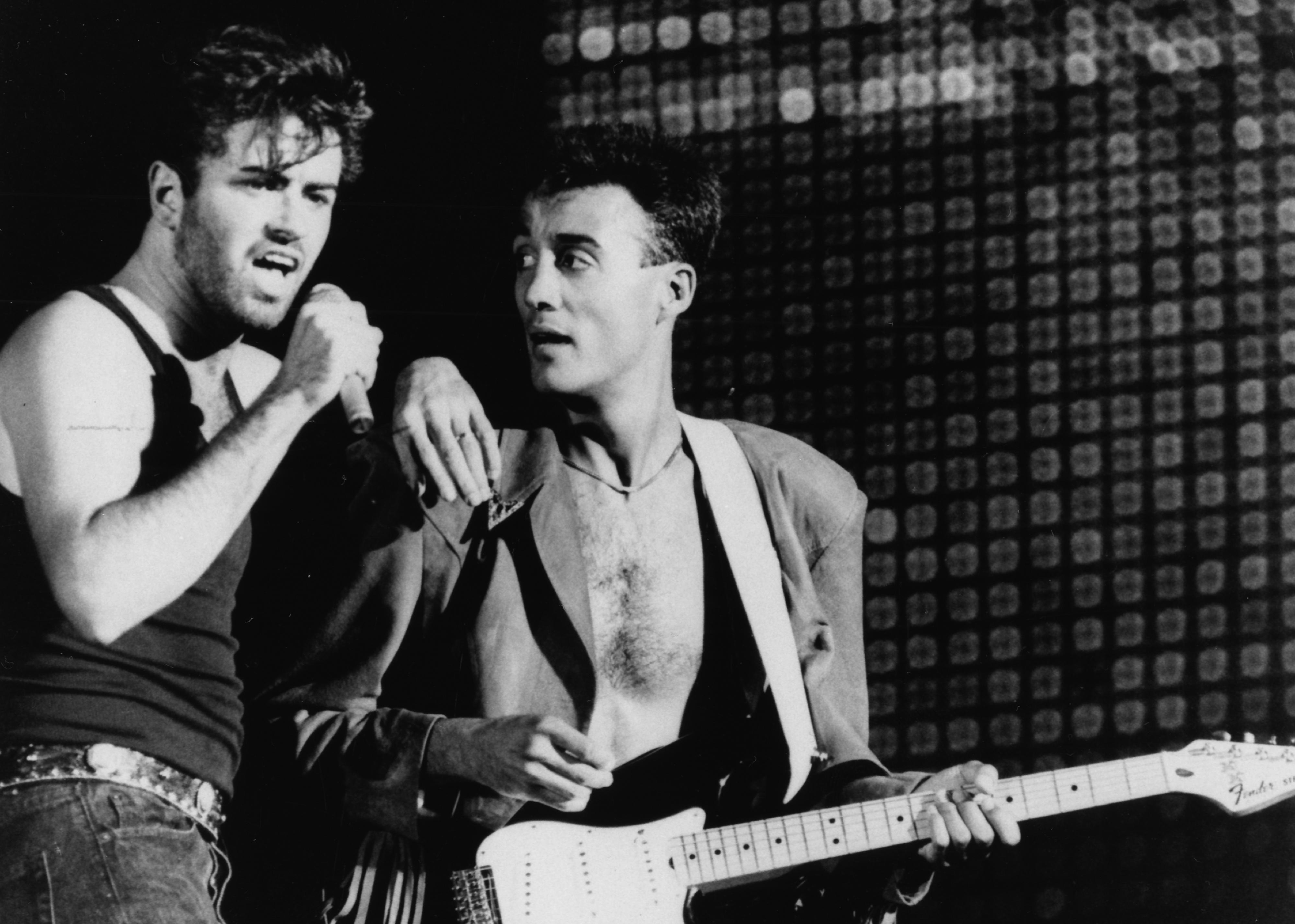 George Michael and Andrew Ridgeley performing on stage.