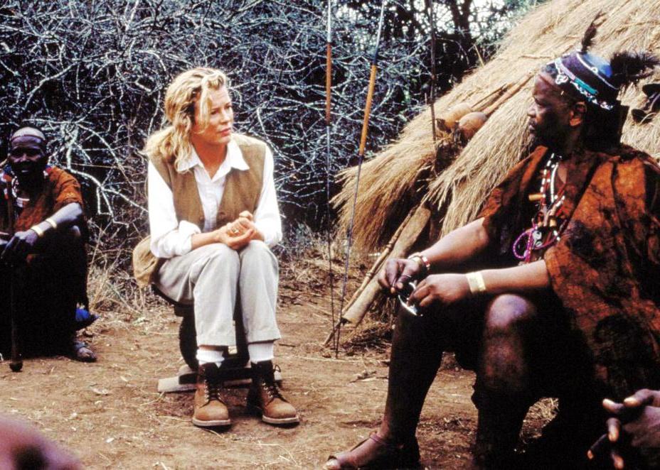 Kim Basinger sits with tribe members in Africa.